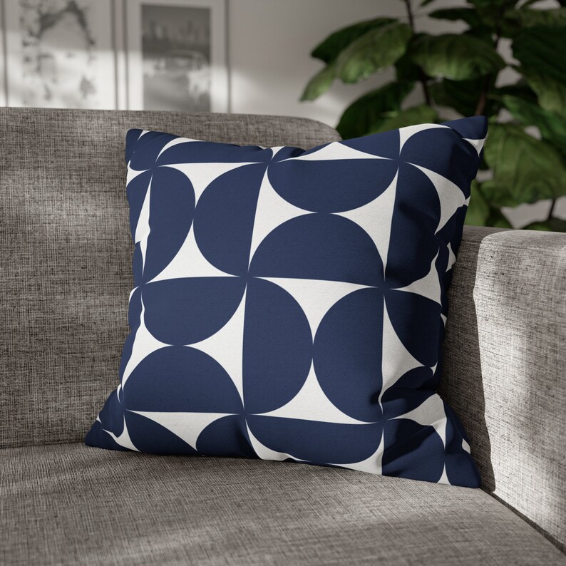 May include: A navy blue and white geometric patterned cushion. The cushion is square shaped and features a repeating pattern of semi-circles.