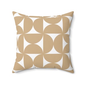 May include: Square throw pillow with a geometric pattern. The design features alternating tan and white semi-circles arranged in a grid. The pillow has a soft, textured appearance, suitable for home decor.