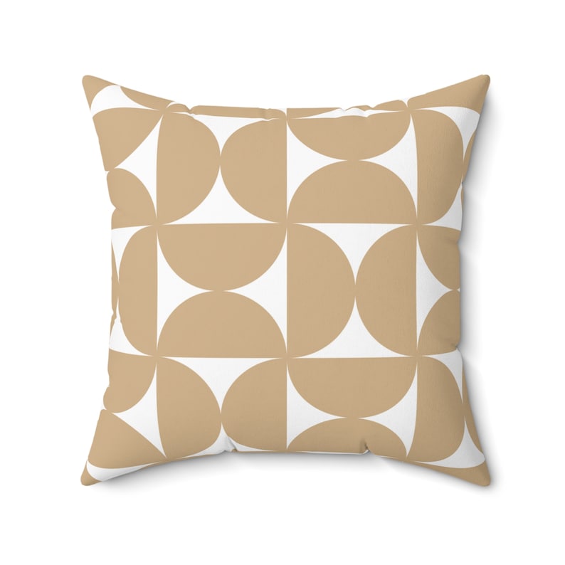 May include: Square throw pillow with a geometric pattern. The design features alternating tan and white semi-circles arranged in a grid. The pillow has a soft, textured appearance, suitable for home decor.