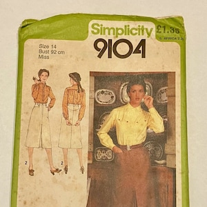 May include: A vintage Simplicity sewing pattern packet, size 14, featuring a woman in a yellow blouse and brown skirt. The packet has illustrations of the outfit and the text "Simplicity 9104". The bust size is 92 cm.