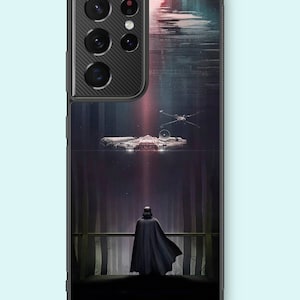 May include: A black phone case with a dark forest scene featuring Darth Vader standing on a platform, looking up at a spaceship flying overhead. The case has a black camera bump with a carbon fiber texture.