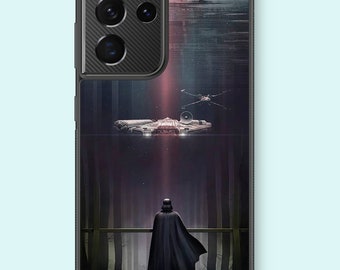 May include: A black phone case with a dark forest scene featuring Darth Vader standing on a platform, looking up at a spaceship flying overhead. The case has a black camera bump with a carbon fiber texture.