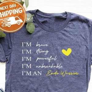 Pu&ograve; includere: Una maglietta blu navy con il testo "I'm brave, I'm strong, I'm powerful, I'm unbreakable, I'm an Endo Warrior" in lettere bianche. Un cuore giallo &egrave; a destra del testo.
