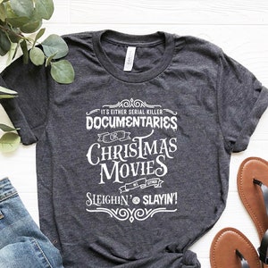 May include: A dark gray t-shirt with white text that reads "It's either serial killer documentaries or Christmas movies. We're either sleighin' or slayin'!".
