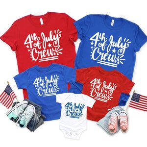May include: Red, white, and blue t-shirts and a white onesie with the text "4th of July Crew". The image includes children's clothing, shoes, and American flags, perfect for Independence Day celebrations.