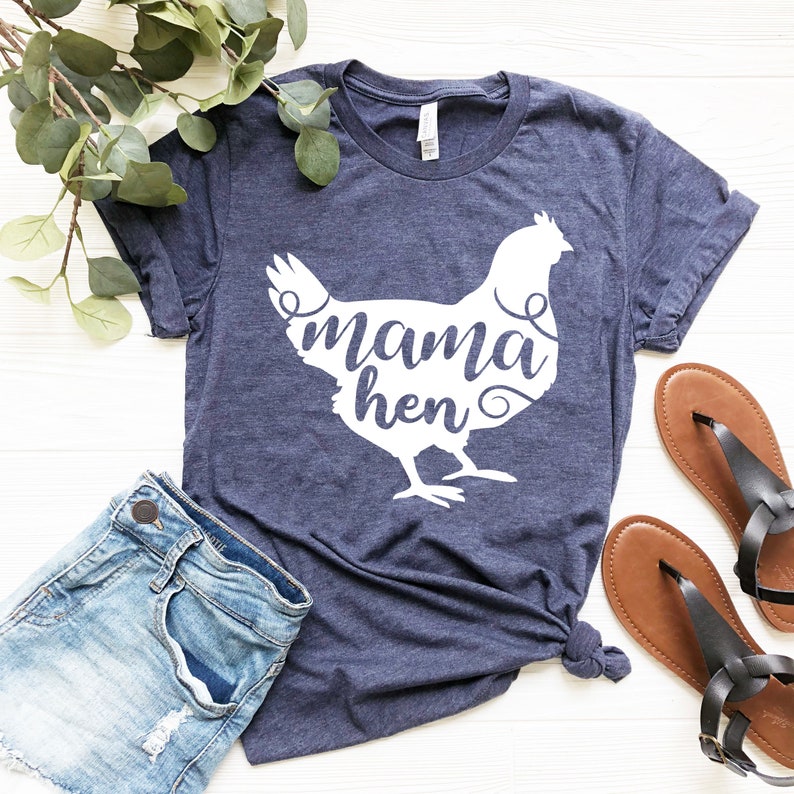 May include: A navy blue t-shirt with a white silhouette of a chicken and the text "mama hen" inside the silhouette.