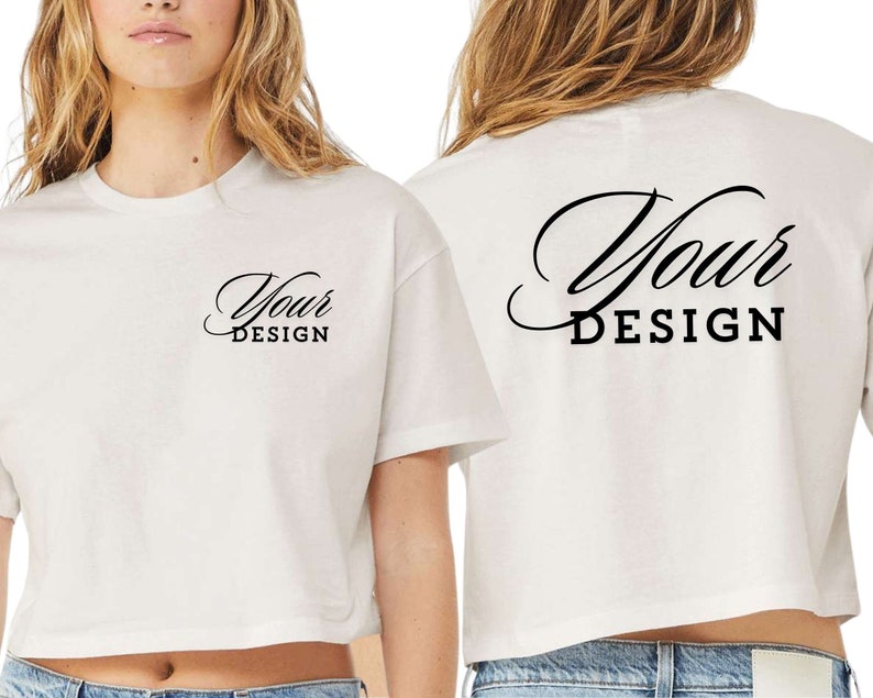 Op de afbeelding: Wit gecropped T-shirt met korte mouwen. De voorkant van het shirt heeft de tekst "Your Design" erop gedrukt. De achterkant van het shirt heeft de tekst "Your DESIGN" erop gedrukt in een groter, decoratiever lettertype.