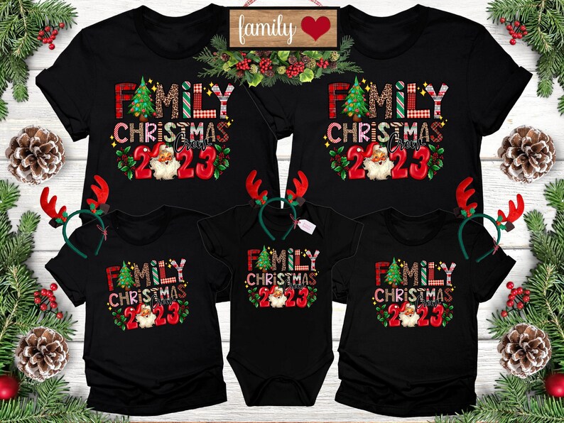 May include: Black t-shirts with the text "FAMILY CHRISTMAS CREW 2023" in a festive design, featuring a Christmas tree and Santa Claus. Includes matching baby onesie and reindeer antlers.