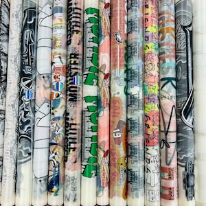 K&ouml;nnte beinhalten: Eine Sammlung von 15 bunten, aufgerollten Aufklebern mit verschiedenen Designs, darunter ein Cartoon-Geist, ein Monster, eine tropfende gr&uuml;ne Figur, ein Cartoon-Charakter mit einem Hut, ein Fu&szlig;ballspieler, ein Cartoon-Charakter mit einem rosa Hut, ein Cartoon-Charakter mit einem blauen Hut, ein Cartoon-Charakter mit einem gr&uuml;nen Hut, ein Cartoon-Charakter mit einem roten Hut, ein Cartoon-Charakter mit einem gelben Hut, ein Cartoon-Charakter mit einem lila Hut, ein Cartoon-Charakter mit einem schwarzen Hut, ein Cartoon-Charakter mit einem wei&szlig;en Hut, ein Cartoon-Charakter mit einem braunen Hut und ein Cartoon-Charakter mit einem grauen Hut.