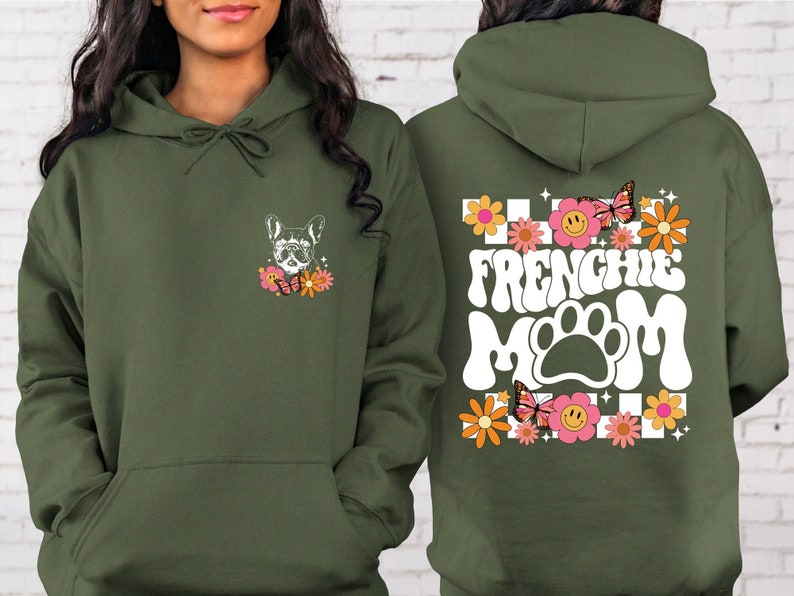 K&ouml;nnte beinhalten: Gr&uuml;ner Kapuzenpullover mit einem wei&szlig;en Grafikdruck eines franz&ouml;sischen Bulldoggen mit Blumen und Schmetterlingen auf der Vorderseite und dem Text "Frenchie Mom" mit einem Pfotenabdruck und Blumen auf der R&uuml;ckseite.