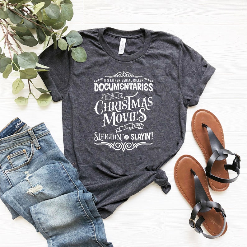 May include: A dark gray t-shirt with white text that reads "It's either serial killer documentaries or Christmas movies. We're either sleighin' or slayin'!".
