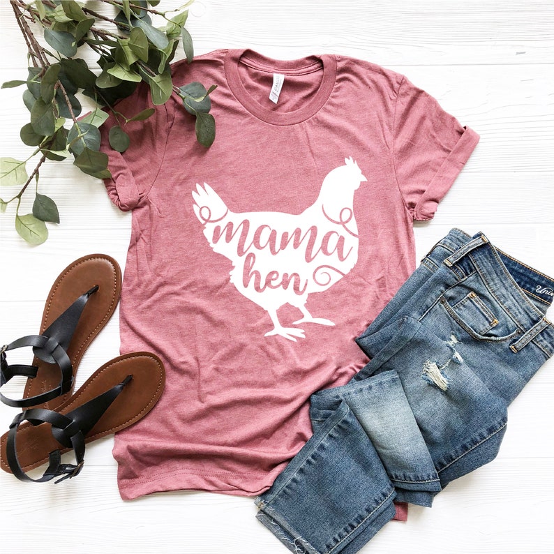 May include: A pink t-shirt with a white silhouette of a chicken and the text "mama hen" on the front.
