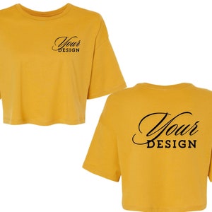 Op de afbeelding: Een mosterdgeel gecropped T-shirt met korte mouwen. De voorkant van het shirt heeft de tekst "Your Design" erop gedrukt. De achterkant van het shirt heeft de tekst "Your Design" erop gedrukt.