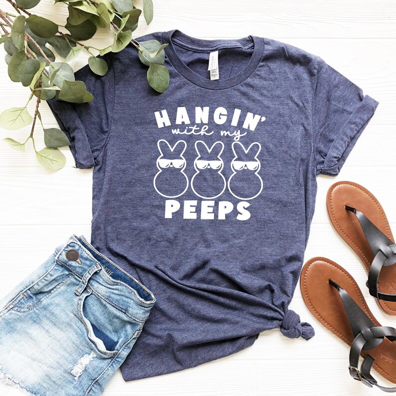 May include: A navy blue t-shirt with a white graphic of three cartoon Peeps wearing sunglasses and the text "Hangin' with my Peeps".