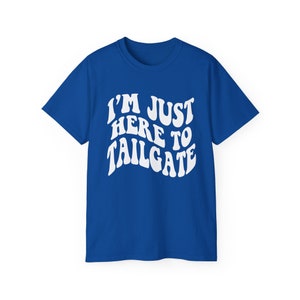 May include: A royal blue t-shirt with white text that reads "I'm Just Here To Tailgate" in a retro font.