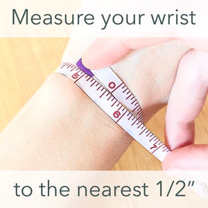 Peut inclure: Un ruban &agrave; mesurer blanc est enroul&eacute; autour du poignet d'une personne pour mesurer la taille du poignet au plus pr&egrave;s de 1/2 pouce. Mesurez votre poignet au plus pr&egrave;s de 1/2 pouce.