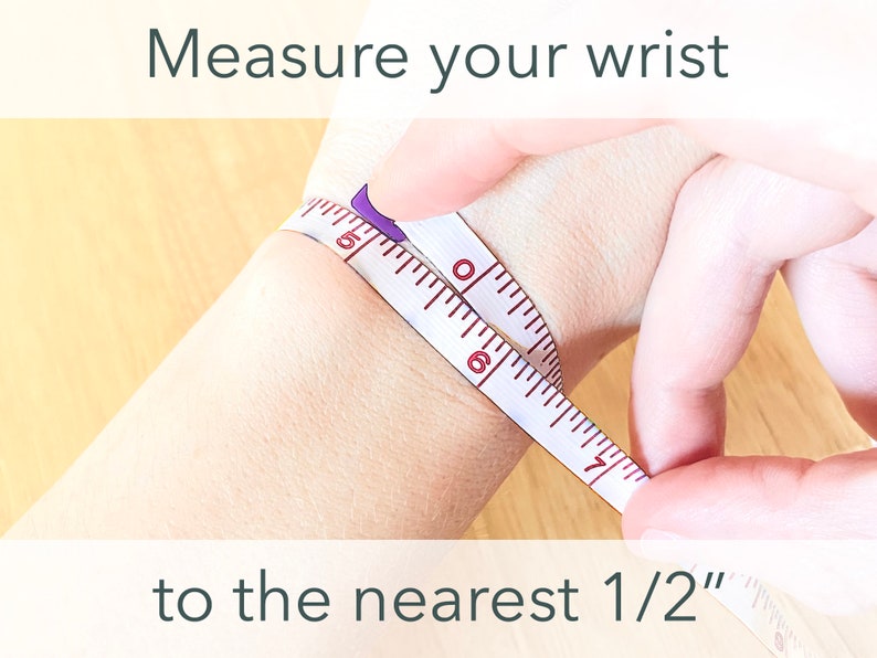 Peut inclure: Un ruban &agrave; mesurer blanc est enroul&eacute; autour du poignet d'une personne pour mesurer la taille du poignet au plus pr&egrave;s de 1/2 pouce. Mesurez votre poignet au plus pr&egrave;s de 1/2 pouce.