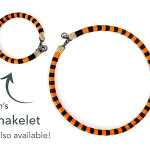Puede incluir: Dos pulseras de rayas naranja y negras, una m&aacute;s grande que la otra. La pulsera m&aacute;s peque&ntilde;a est&aacute; etiquetada como "Men's Snakelet also available!"
