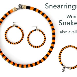 Puede incluir: Collar, pendientes y pulsera a rayas naranja y negro. El texto "Snearrings & Women's Snakelet also available!" es visible en la imagen.