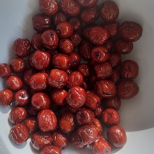 Puede incluir: Un taz&oacute;n blanco lleno de d&aacute;tiles rojos secos.