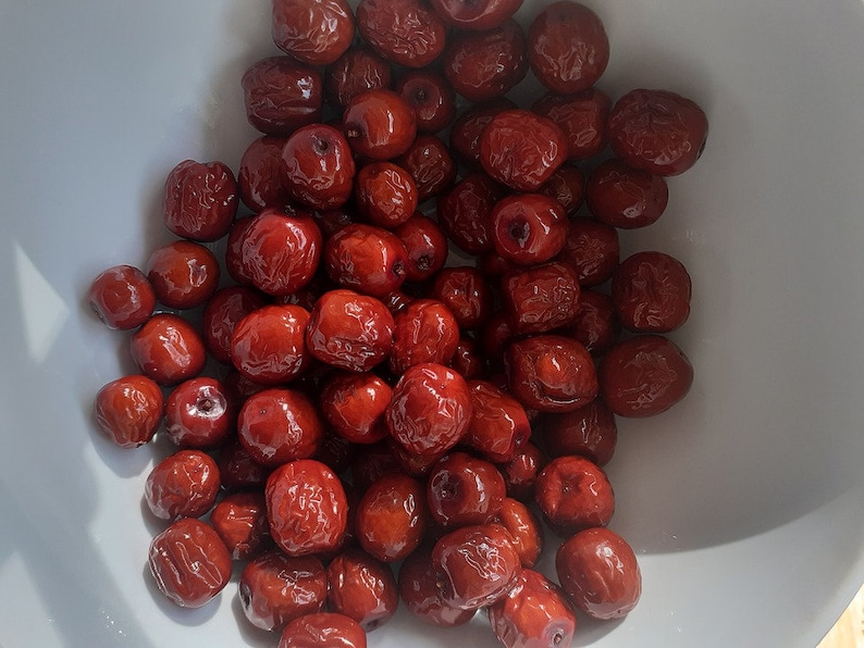 Puede incluir: Un taz&oacute;n blanco lleno de d&aacute;tiles rojos secos.