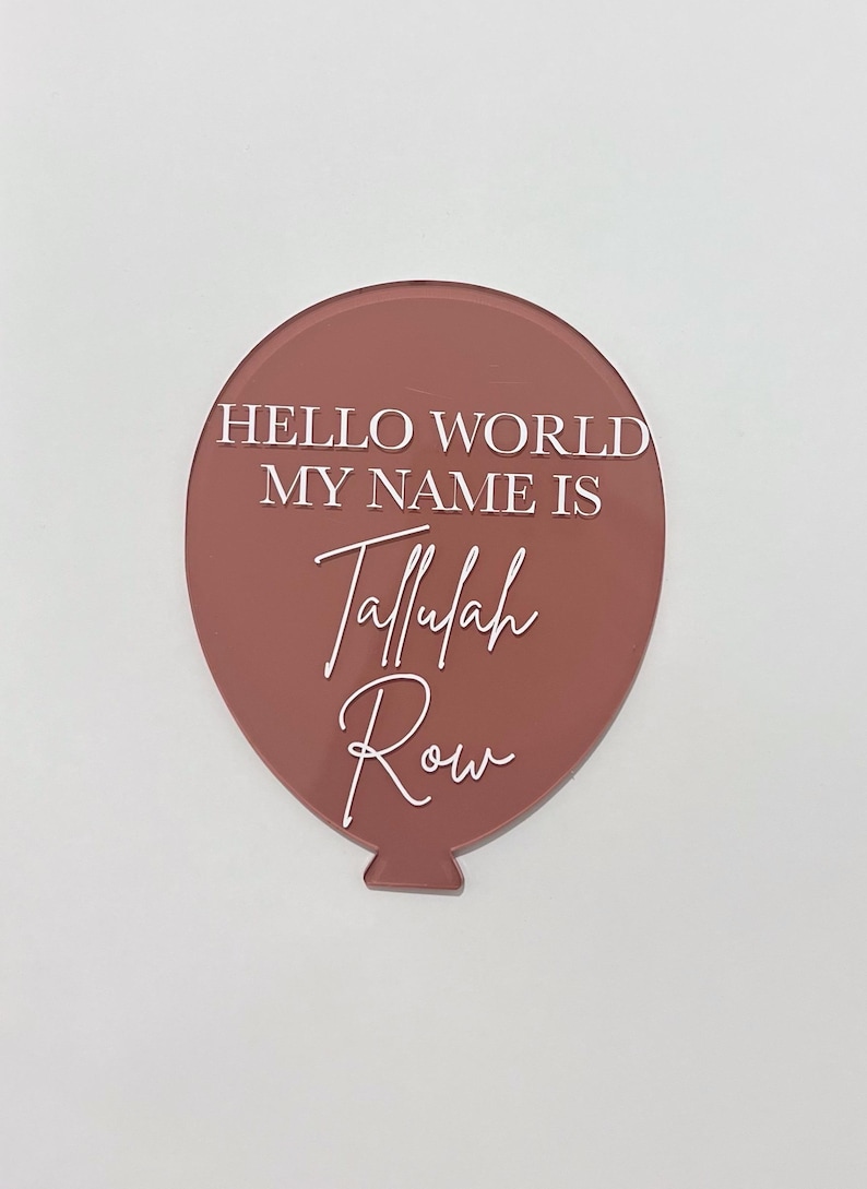May include: A pink balloon with the text "Hello World My Name Is Tallulah Row" in white lettering.