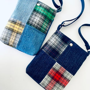 May include: Two small denim and plaid patchwork crossbody bags with adjustable straps. The bags are made of different colored denim and plaid fabrics.