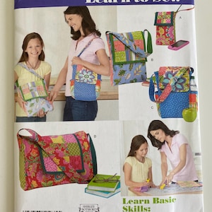 May include: A Simplicity 1935 Learn to Sew pattern envelope featuring illustrations of four different fabric messenger bags and pouches. The designs include various floral and geometric patchwork patterns in blue, green, pink, and yellow colors.