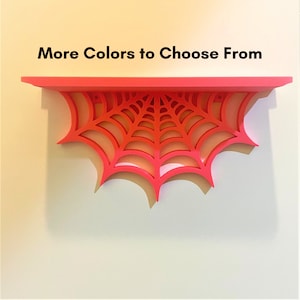 May include: A bright red shelf with a spiderweb design. The shelf is made of wood and has a smooth finish.  More Colors to Choose From.