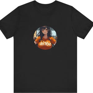 May include: Black t-shirt with a circular graphic of an anime-style character wearing an orange shirt with the text "ai16z". The character has dark hair and is smiling. The t-shirt is made of a soft material.