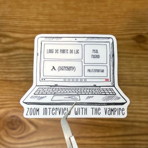 May include: A black and white illustration of a laptop computer with a Zoom meeting screen open. The screen displays the text "LOUIS DE POINTe Du Lac", "real PASHID", "A. (Disregard!)", and "PULITZCROOTWO". The laptop has the text "ZOOM Intervie! WITH THE Vampire" on the bottom.
