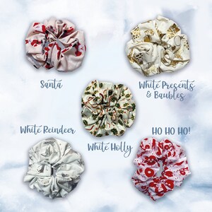 May include: Six different Christmas-themed scrunchies. The scrunchies are made of fabric and have different patterns, including Santa, reindeer, holly, presents, and baubles. The scrunchies are all white with different colored patterns.