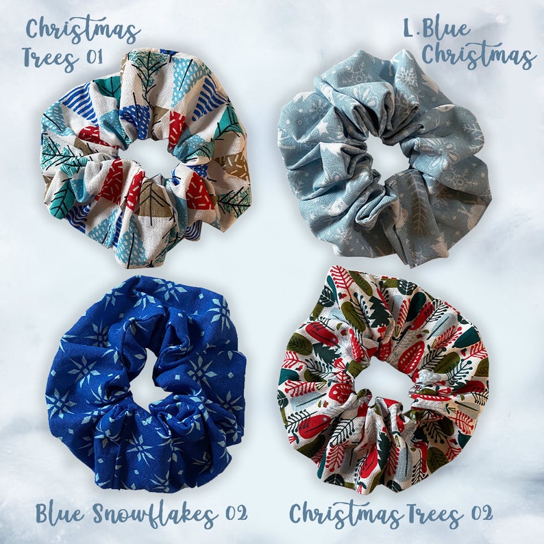May include: Four different Christmas-themed scrunchies. The top left scrunchie is white with red, blue, and green Christmas trees. The top right scrunchie is light blue with a snowflake pattern. The bottom left scrunchie is blue with a snowflake pattern. The bottom right scrunchie is white with red and green Christmas trees.