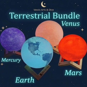 May include: A Terrestrial Bundle set featuring four spherical planet lamps on wooden stands. The lamps represent Mercury in purple, Venus in peach, Earth in blue with visible continents, and Mars in red. Text reads Vera's Arts & Dice.