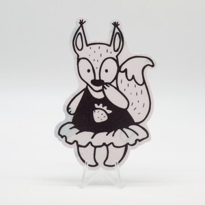 Peut inclure: Illustration en noir et blanc d'un écureuil portant une robe noire avec un motif de fraise. L'écureuil est debout sur un fond blanc.