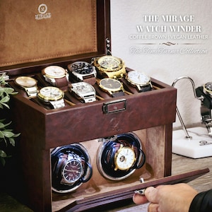 May include: A brown leather watch winder with a clear glass top. The winder has two rotating compartments for watches. The winder is labeled "The Mirage Watch Winder" and "Coffee Brown | Vegan Leather".
