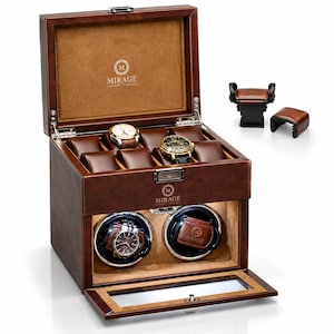 May include: A brown leather watch winder box with a hinged lid, featuring a tan interior, multiple watch pillows, and two circular winding compartments. The Mirage Luxury Travel logo is printed on the lid and front. Includes two extra watch cushions.