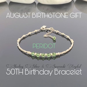May include: A silver bracelet with a twisted design and green peridot crystals. The bracelet is labelled "Sterling Silver & Swarovski Crystal 50TH Birthday Bracelet" and "PERIDOT".