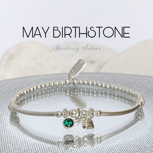 May include: Sterling silver bracelet with a green birthstone charm and a heart charm. May Birthstone.