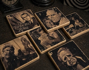 May include: Set of six square wooden coasters featuring black and white images of actors and scenes from the television show "The Twilight Zone." One coaster displays the show's title. The coasters have a distressed, vintage aesthetic.