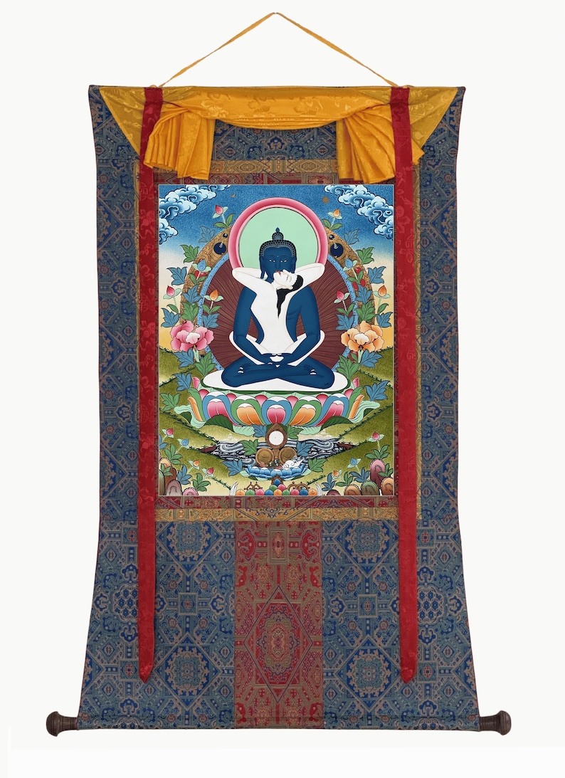 May include: A vertical wall hanging scroll featuring a central thangka painting of a blue deity embracing a white figure in a lotus position. The artwork is framed by a blue and red patterned fabric border with a yellow silk top header and ribbon.