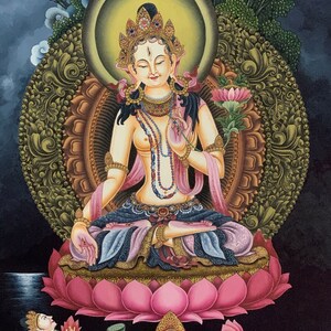 May include: A colorful painting of a deity sitting on a lotus flower. The deity is adorned with jewelry and has a serene expression. The painting is set against a dark background with a moon in the upper left corner.