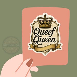 May include: A pink rectangle with a graphic that reads "Queef Queen" in a vintage style font. The graphic includes a gold crown and banner. The card is held by a hand with a painted nail.