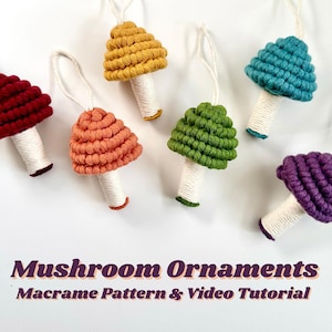 Puede incluir: Adornos de setas de macramé multicolores en rojo, naranja, amarillo, verde, turquesa y morado. Cada seta tiene un tallo blanco y un lazo para colgar. El texto "Mushroom Ornaments Macrame Pattern & Video Tutorial" está en la parte inferior.