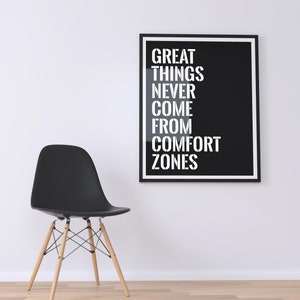 May include: A black and white motivational poster with the text "GREAT THINGS NEVER COME FROM COMFORT ZONES" hanging on a white wall above a black chair with wooden legs.