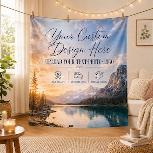 Op de afbeelding: Een op maat bedrukt stoffen wandkleed met een landschap van een meer omringd door bergen en dennenbomen bij zonsondergang. De tekst luidt Your Custom Design Here, UPLOAD YOUR TEXT-PHOTO-LOGO, HIGH QUALITY, MULTIPLE SIZES, VIBRANT COLORS.