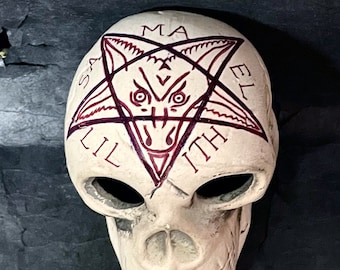 May include: White ceramic skull with a red pentagram and the words "LILITH" and "MAMA" on the forehead.