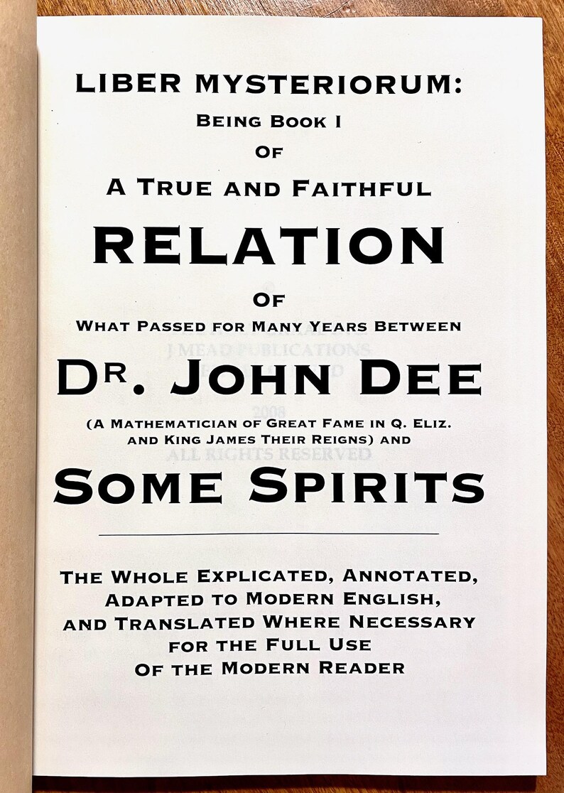 May include: A book cover with the title "Liber Mysteriorum" in large, bold black letters. The text below details the book's contents, including the names "Dr. John Dee" and "Some Spirits". The cover is white with black text.