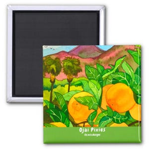 May include: A square magnet with a watercolor painting of oranges, green leaves, and palm trees. The background features a mountain range and blue sky. The text "Ojai Pixies" is displayed on a green banner.
