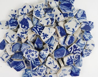 May include: A collection of blue and white ceramic tile pieces with various floral and geometric patterns. The tiles are broken into irregular shapes and sizes.